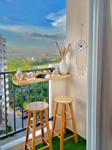 a balcony with a desk and two stools at Maison kh in Suba