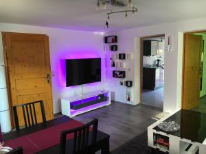 a living room with a tv and purple lights at Bungalow am Bach - zwischen Brocken und Schloß in Wernigerode