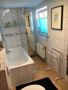 a bathroom with a shower and a tub and a toilet at Bungalow am Bach - zwischen Brocken und Schloß in Wernigerode +21 photos