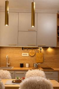 a kitchen with white cabinets and a wooden counter top at Konaci Prime Center in Kopaonik