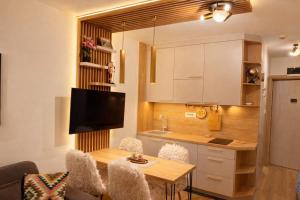 a kitchen with a table and a kitchenette with a dining room at Konaci Prime Center in Kopaonik