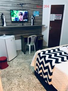 een slaapkamer met een bed, een bureau en een tv bij Hotel Pousada-LG in Breves +14 foto's