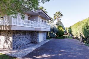 a house with a balcony on the side of a driveway at Finca Aquí Me Quedo in Murcia