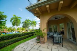 een patio met stoelen en tafels op een huis bij Bella Vista 3F 3 bdr beach club view in Los Suenos in Herradura