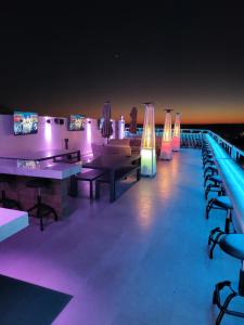 a bar with ping pong tables and purple lights at hotel cuatro palmas in Puerto Peñasco
