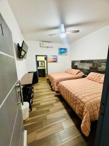 a room with two beds and a piano in it at hotel cuatro palmas in Puerto Peñasco