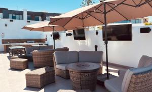 a patio with chairs and an umbrella and a table at hotel cuatro palmas in Puerto Peñasco