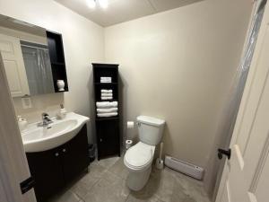 a bathroom with a white toilet and a sink at Studio #1 avec balcon tout inclus in Baie-Comeau