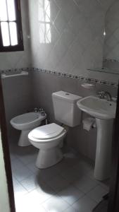 a white bathroom with a toilet and a sink at maemm el castillto in Mina Clavero