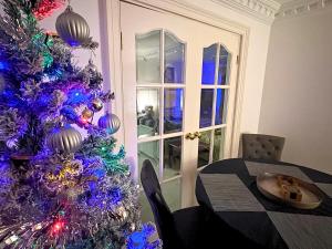 een paarse kerstboom in een eetkamer met een tafel bij Fulwood House in Grimsargh