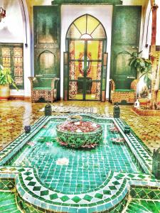 una piscina al centro di una stanza con una fontana di Riad ABBASSIA Marrakech Premiere - Authentic Medina Experience a Marrakech