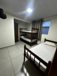 a bedroom with two bunk beds and a window at Hostel Salazar in Campo Grande