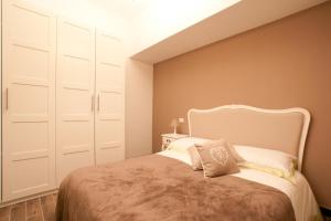 1 dormitorio con 1 cama con armarios blancos en Your Sweet Home, en Génova