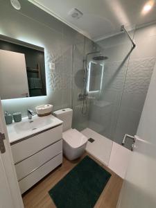 a bathroom with a toilet and a sink and a shower at Apartamento - The Light House in Peniche