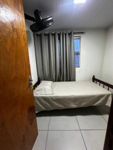 a small bedroom with a bed and a window at Hostel Salazar in Campo Grande