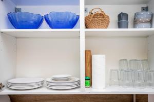 una dispensa bianca con piatti e piatti sugli scaffali di Easy Flexhome Hostel a Berlino Altre 8 foto