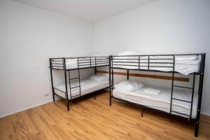 2 letti a castello in una camera con pavimento in legno di Easy Flexhome Hostel a Berlino