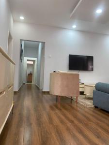 ein Wohnzimmer mit Sofa und Flachbildfernseher in der Unterkunft Maculusso City Stay in Luanda