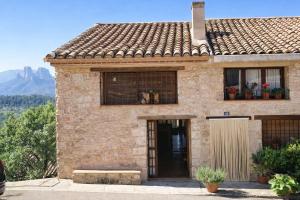 a stone house with two windows and a door at Ca l'Era in Horta de San Joan