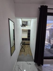 a room with a hallway with a mirror and a chair at Loft2 PB in Mérida