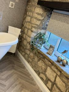 a bathroom with a stone wall and a sink at Church view in Conisbrough