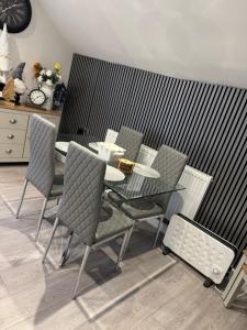 a dining room with a table and chairs and a clock at Church view in Conisbrough +7 photos