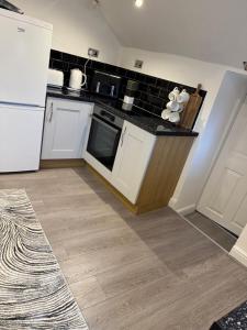 a kitchen with white appliances and a wooden floor at Church view in Conisbrough