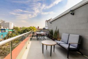 un balcon avec des chaises et une table sur un immeuble dans l'établissement Colmena Hotel CDMX Tonala, à Mexico