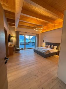 a bedroom with a bed and a large window at MALIA - Alpine Hideaway in Pertisau