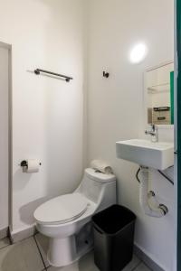 une salle de bains blanche avec toilettes et lavabo dans l'établissement Colmena Hotel CDMX Tonala, à Mexico 26 autres photos