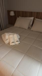a bed with two towels on it with at Flat completo e confortável in Cuiabá