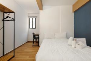 une chambre avec un lit blanc et une table dans l'établissement Colmena Hotel CDMX Tonala, à Mexico