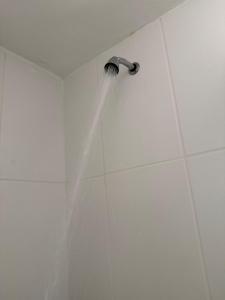 a shower head with a stream of water at Flat completo e confortável in Cuiabá +15 photos