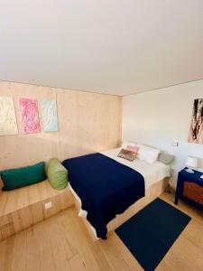 a bedroom with a large bed with a blue blanket at Casa Do Guarda Rios in Ponte Nova