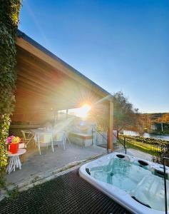 a hot tub on a patio with a table and chairs at Casa Do Guarda Rios in Ponte Nova