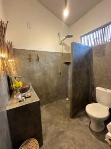 een badkamer met een toilet, een wastafel en een douche bij Casa Vento Curimãs in Barroquinha