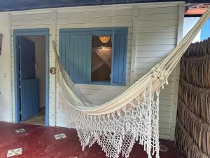 een hangmat aan de zijkant van een huis bij Casa Vento Curimãs in Barroquinha +47 foto's