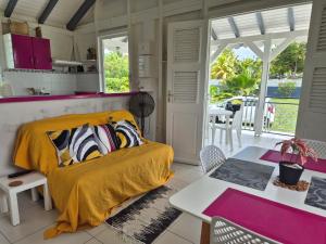 een slaapkamer met een bed, een tafel en stoelen bij "Fleur d'Hibiscus" Maison de charme au calme à Marie-Galante in Saint-Louis