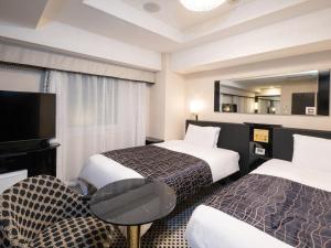 una camera d'albergo con due letti e un tavolo di APA Hotel Kodemmacho Ekimae a Tokyo