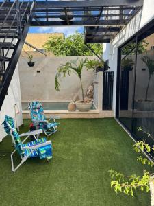 a patio with a lawn and a chair on it at Loft2 PB in Mérida