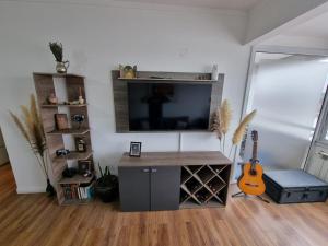 a living room with a flat screen tv and a guitar at Premium apartment San Luis Centro in San Luis +2 photos