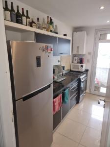 a kitchen with a refrigerator and some bottles of wine at Premium apartment San Luis Centro in San Luis