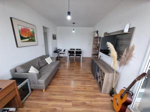 a living room with a couch and a guitar at Premium apartment San Luis Centro in San Luis