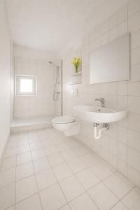 un bagno bianco con lavandino e WC di Zweizimmerwohnung für Monteure & Bauarbeiter a Leuna