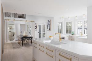 a white kitchen with a sink and a table at Vineyard Estate by the River with Pool in Niagara-on-the-Lake