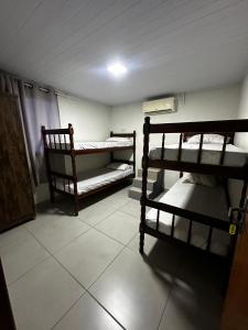 a room with two bunk beds and a tiled floor at Hostel Salazar in Campo Grande