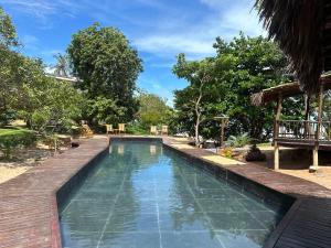 a swimming pool in a resort with trees at Casa Vento Curimãs in Barroquinha