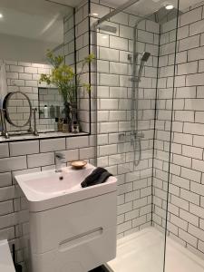 een witte badkamer met een wastafel en een douche bij Windsor Royal Retreat Luxury 1BED Apartment in Windsor