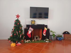 a christmas tree in a living room with a fireplace at SEASTAR nº36 in Horta