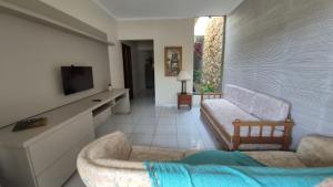 een woonkamer met een bank en een tv bij Casa shalom in Serra Negra